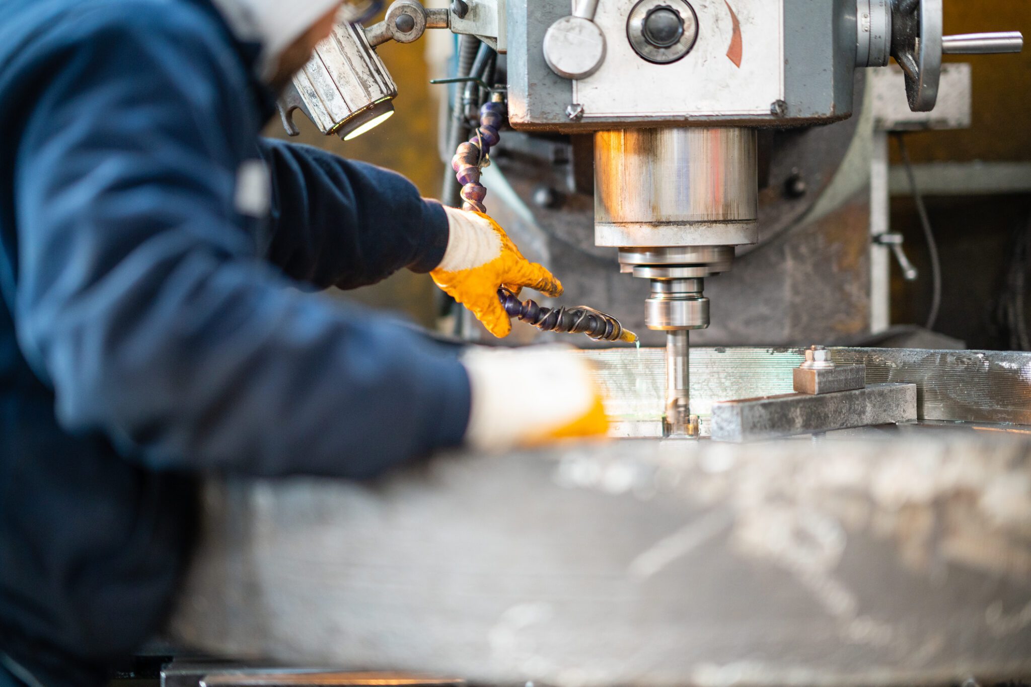 A worker in a factory working on a traditional milling machine`