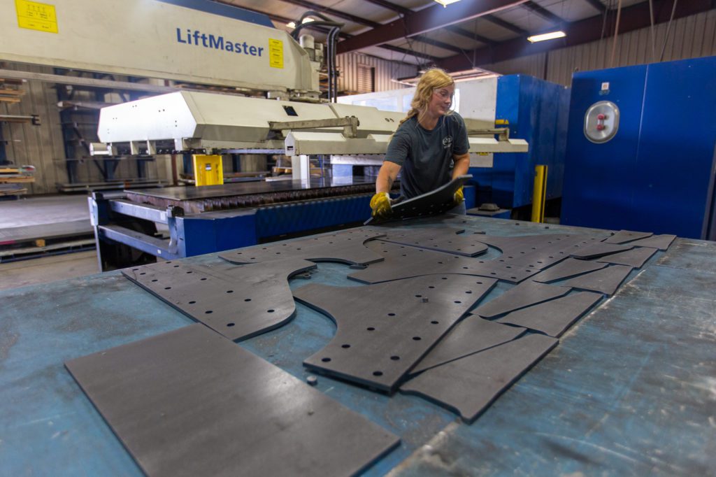 woman metal worker working on metal cutting machine
